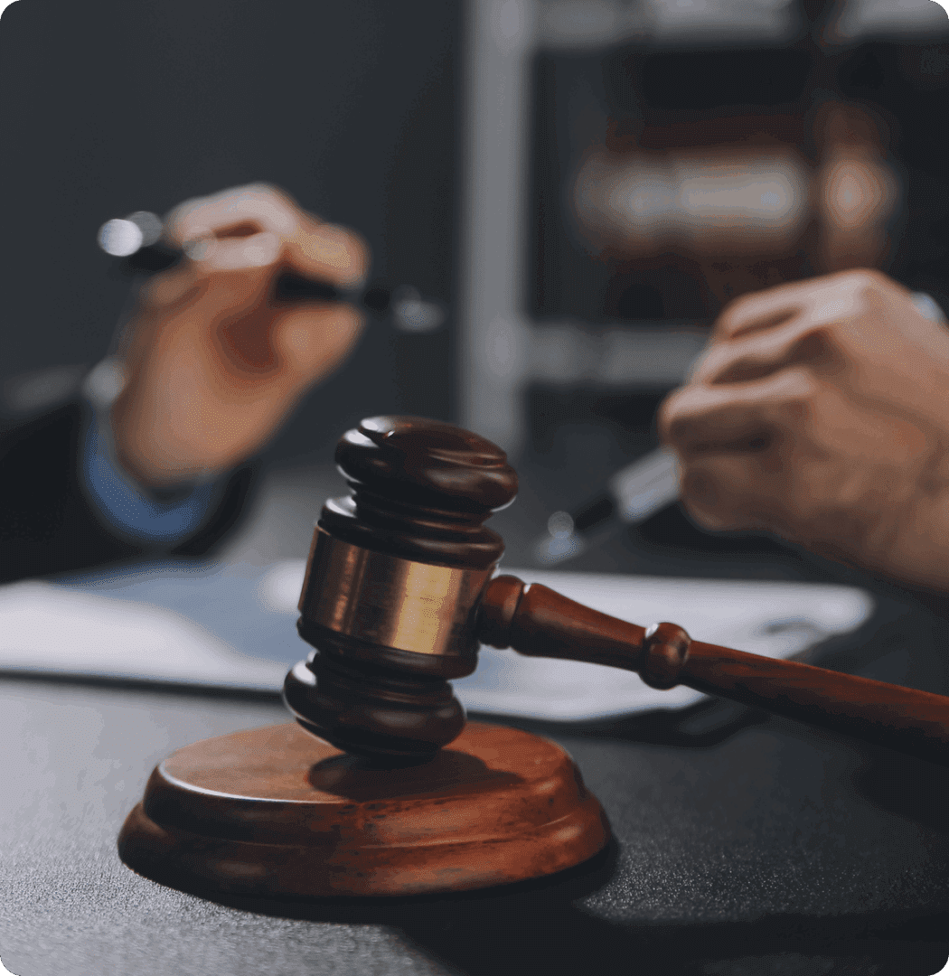 Gavel on table with people writing.