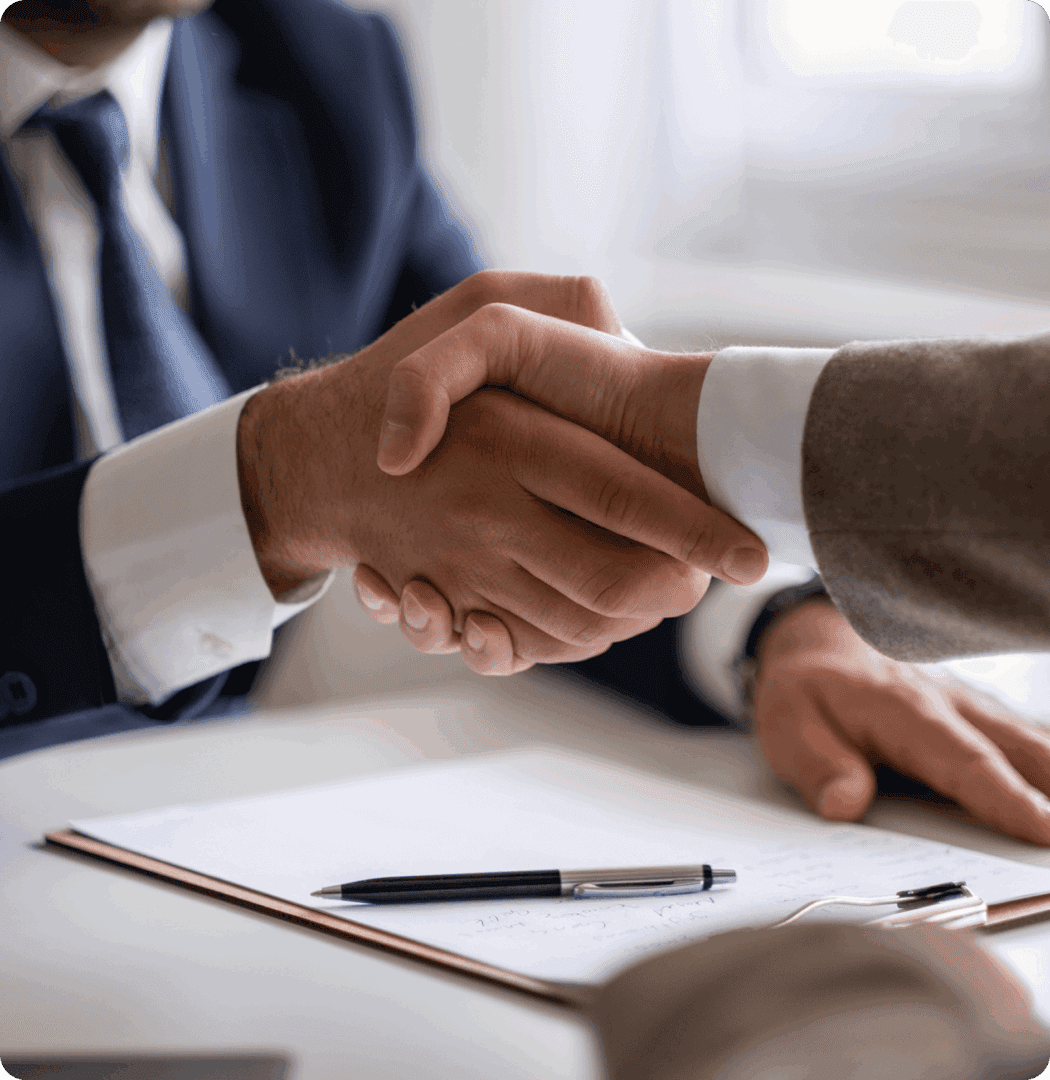 Handshake over a document and pen.
