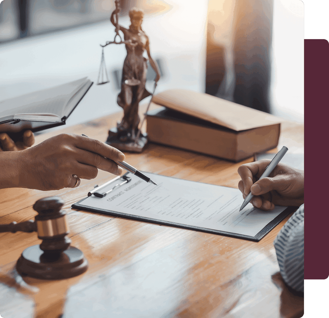 Signing legal documents on a wooden table.
