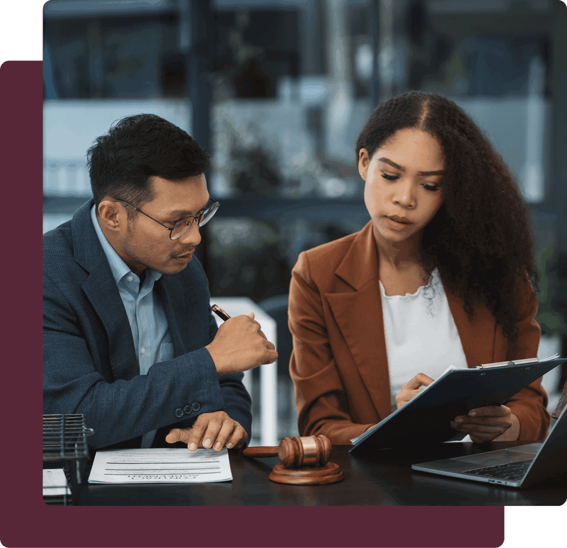 Two professionals reviewing documents at desk.