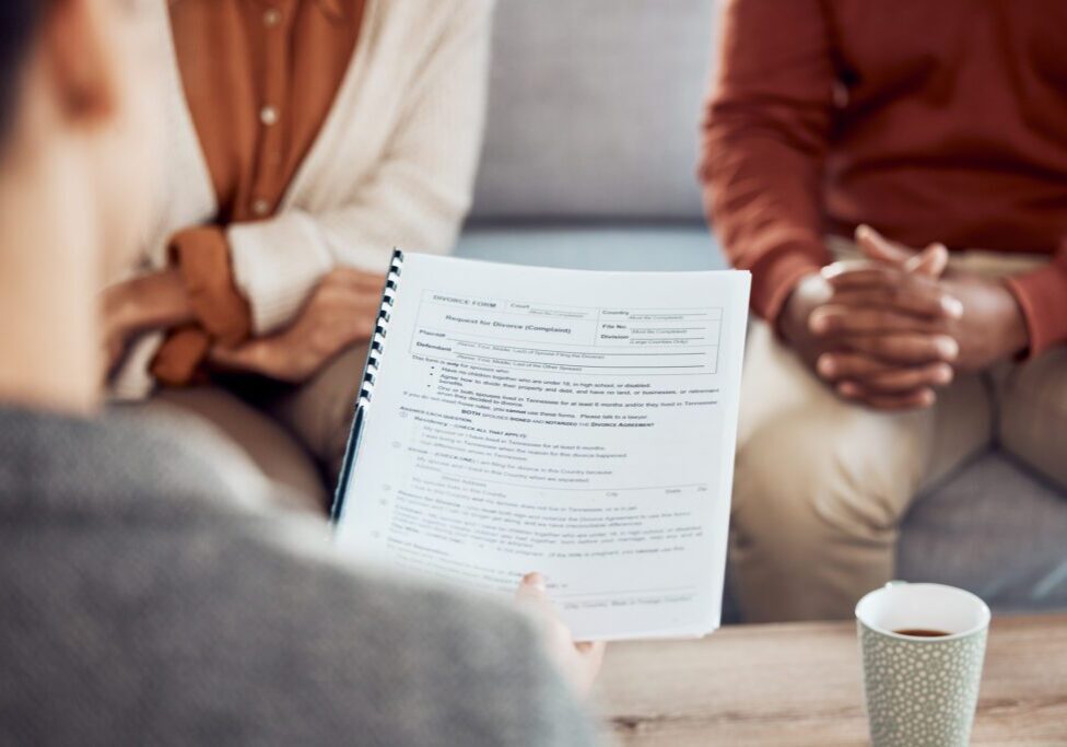 Couple in consultation, reviewing documents and coffee.
